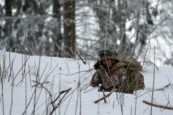 Soldato nella foresta invernale con le armi