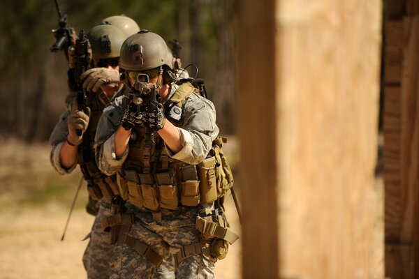 Three soldiers in equipment are advancing