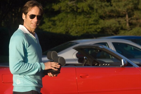 El actor David Duchovny con un coche rojo