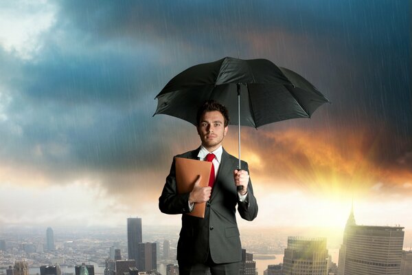 Facet w garniturze z czerwonym krawatem, beżową teczką i odkrytym czarnym parasolem, stoi w deszczu na tle miasta i świtu