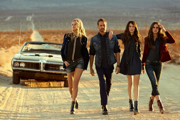 Paul Walker, Isabelle Goulart, and others walk along the road in the desert