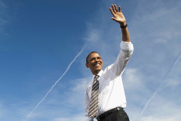Barack Obama souriant a levé la main dans un geste de bienvenue