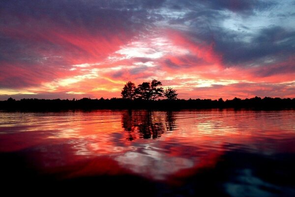 Satter roter Sonnenuntergang über dem Fluss