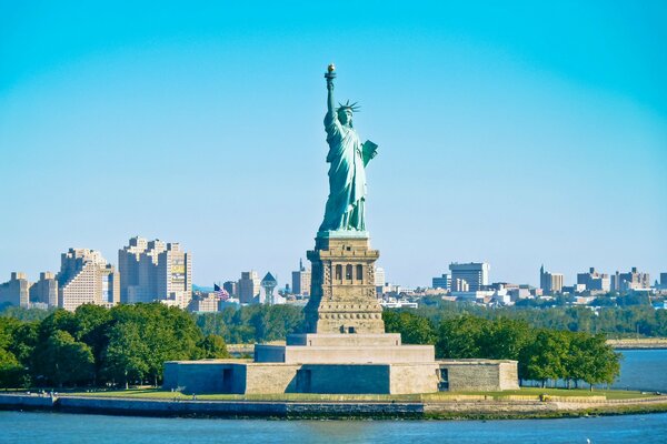 The Statue of Liberty stands majestically against the background of the city