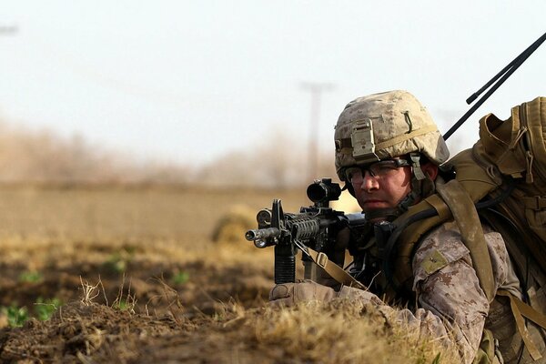 Ein Soldat in einer Uniform mit einer Waffe im Graben