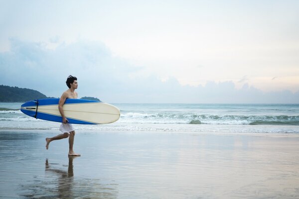 Chico en la playa con una tabla de surf