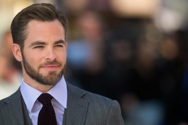 Actor Chris Pine in a suit and tie with a blurry background