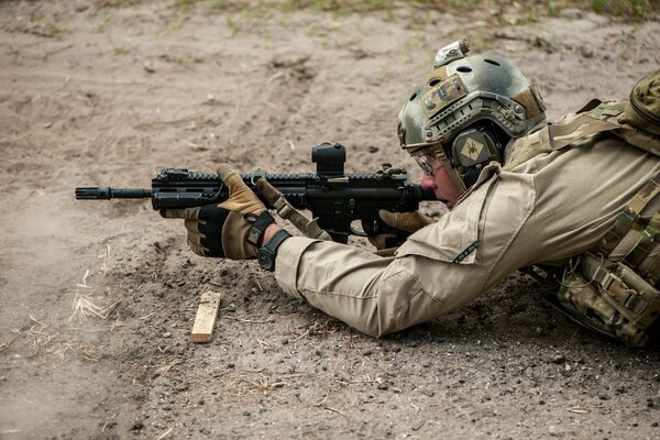 A soldier lies and shoots a weapon