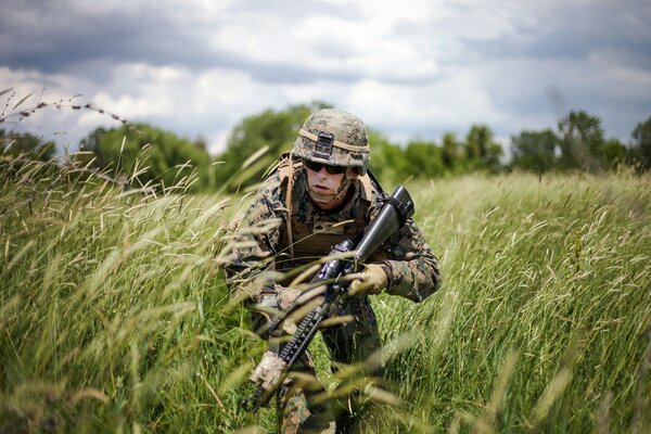A handsome military man with a weapon in the field