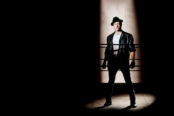 Sylvester Stallone on a black background wearing gloves