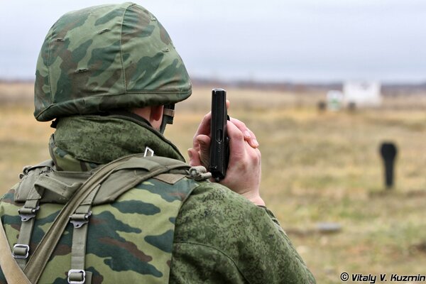 Soldaten in Uniform und Arbeitskleidung am Schießstand