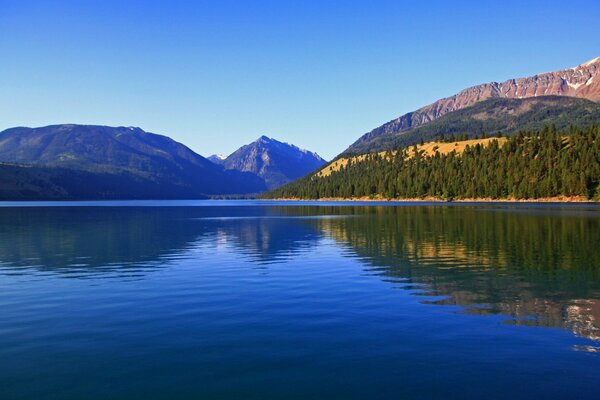 A bright blue lake on the background of the rocky mountains