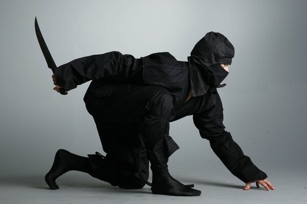 A crouching ninja in a black suit