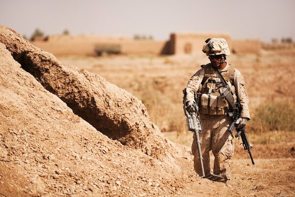 Un soldado en el desierto con armas