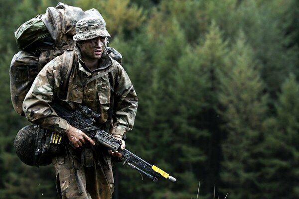 Soldat avec des armes sur fond de forêt