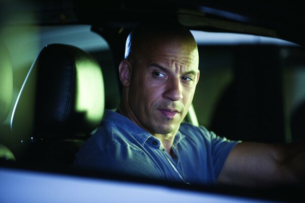 Bald vin diesel is sitting in the car