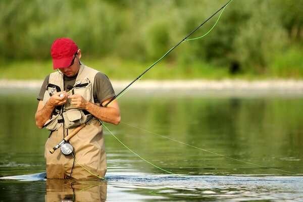 Pescador en el río se aferra a la caña de pescar