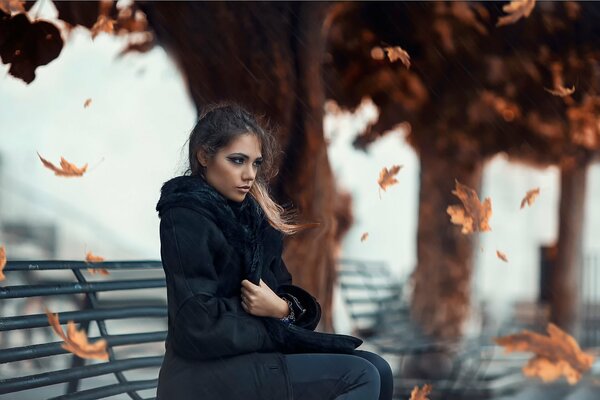 Otoño hermosa chica sentada en un banco