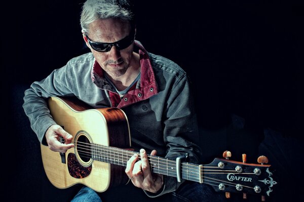 Hombre con estilo tocando la guitarra