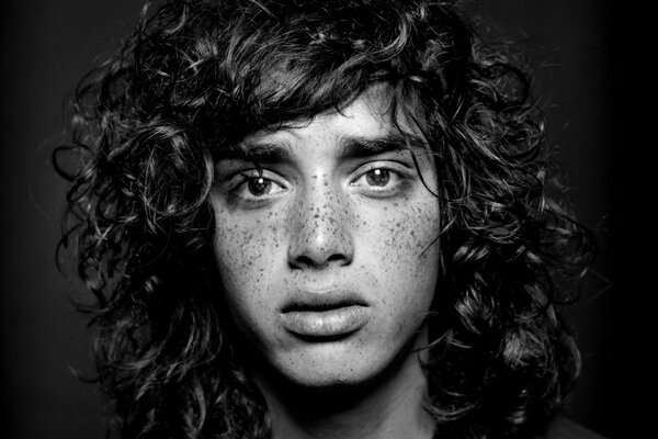 Curly-haired young man with freckles on his face