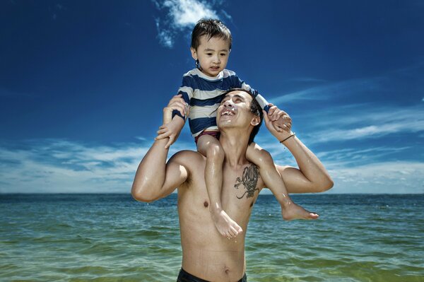Père avec son fils sur les épaules de la mer