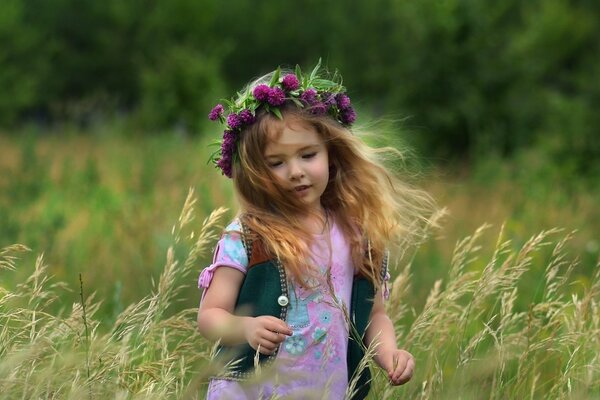 Une fille dans une Couronne court sur un champ. Paysage d été