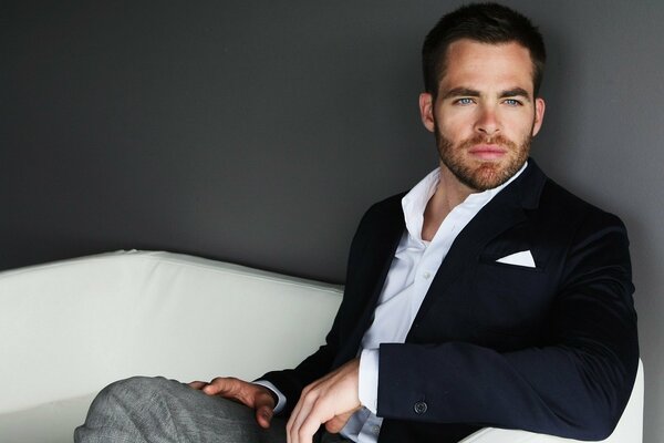 Chris Pine in a jacket on the couch