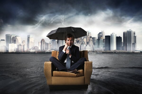 Ein Mann im Anzug sitzt unter einem Regenschirm in einem Sessel