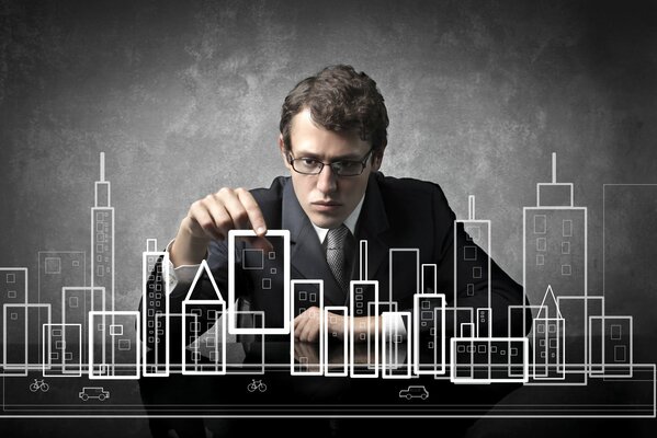 A guy with glasses assembling a mock-up of the city