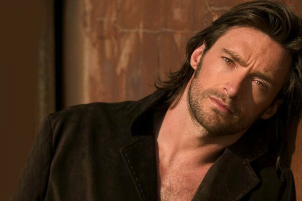 Hugh Jackman with long hair in a jacket on a naked body