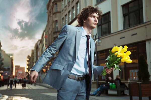 A man in a suit with flowers in his hand