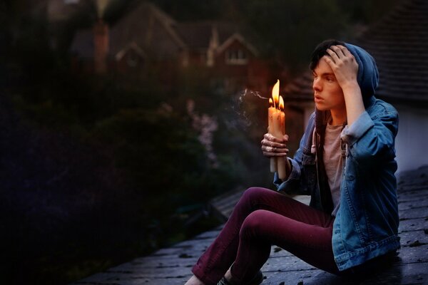 Ragazzo sul tetto con le candele in mano