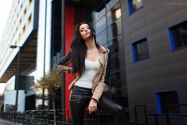 Hermosa morena posando junto al edificio