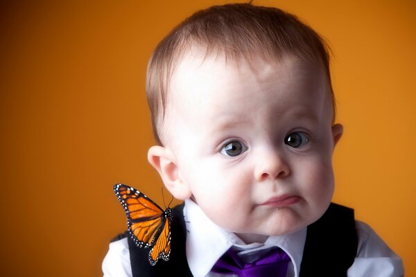 Retrato de un niño con una mariposa en el hombro