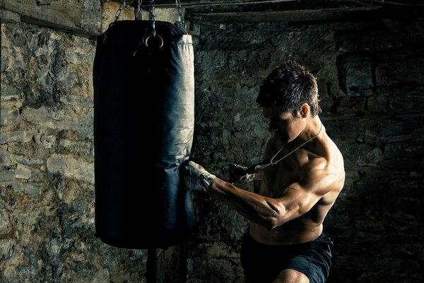 Le gars entraîne les muscles à l aide d une poire de boxe