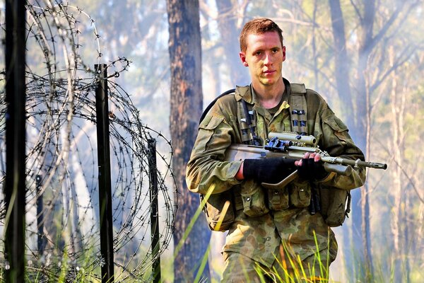 A man with a machine gun in the woods