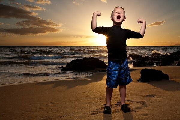 Junge freut sich über Sonnenuntergang am Strand