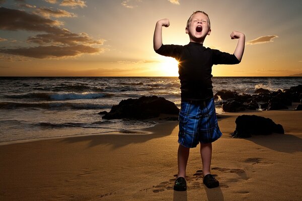 Garçon se réjouit d un coucher de soleil sur la plage