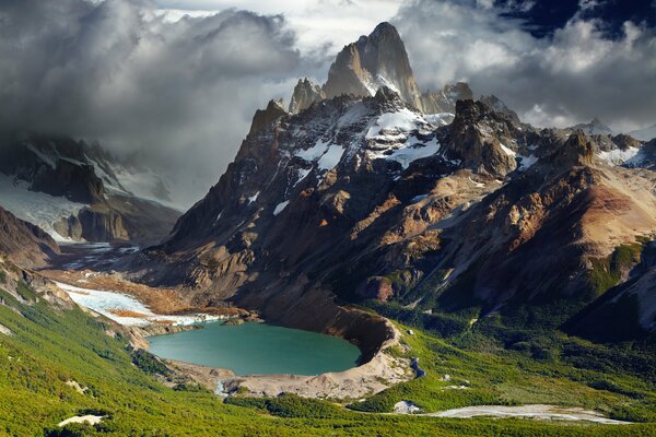 Clouds between the Argentine mountains sweep over the lake