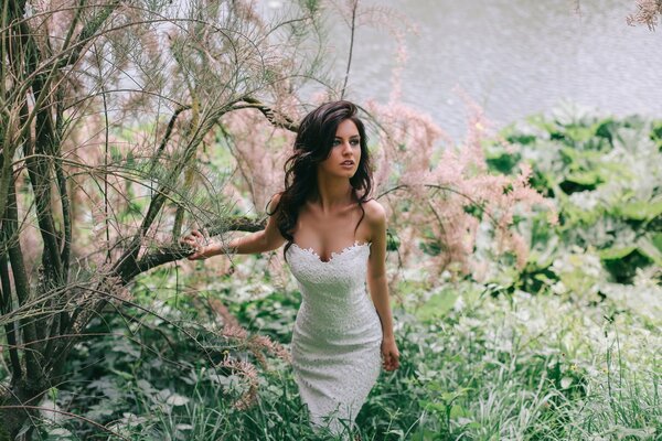 Brunette in a white dress in nature