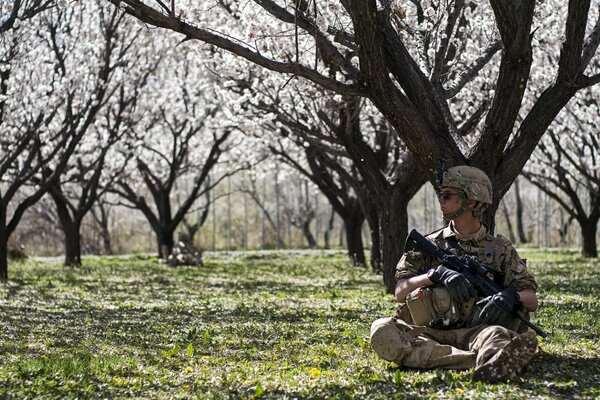 Soldado sentado con armas en el Jardín