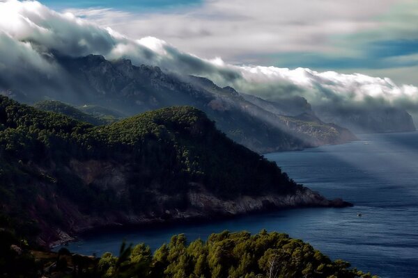 The fog descends from the mountains directly into the water