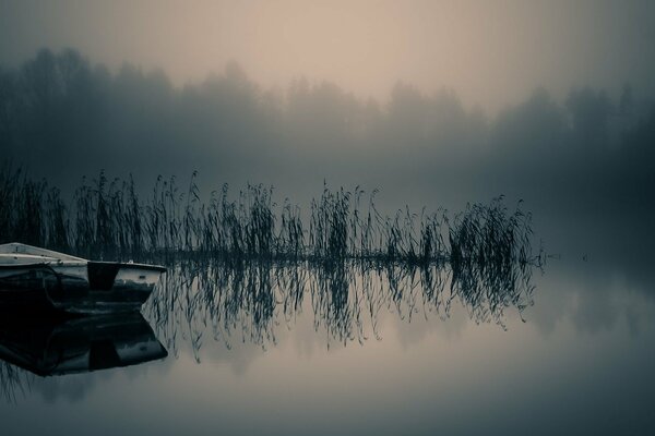 Fog over the river. Boat on the water