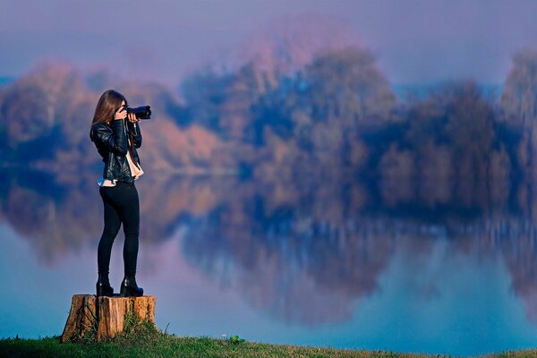 Fotografka Brunetka jesienią fotografuje piękny krajobraz jeziora