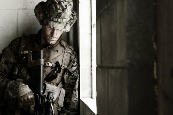 A soldier with a hat and a gun in his hands