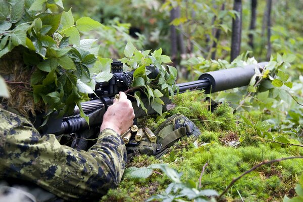 Disfrazarse y usar un rifle en el bosque