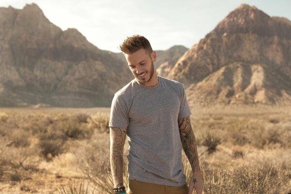 French singer smiles against the background of mountains