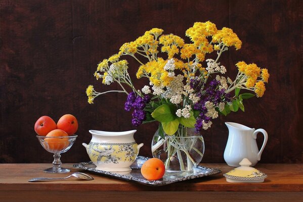 Albaricoques y flores de pie sobre la mesa