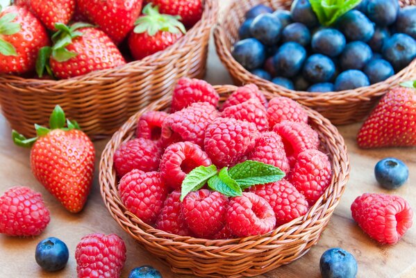 Himbeeren und Blaubeeren in einem Holzkorb