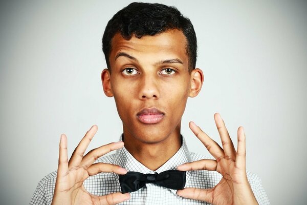 Cantante stromae sostiene una mariposa